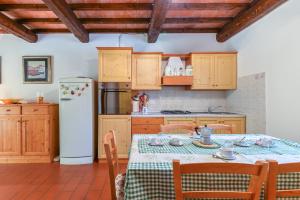 uma cozinha com uma mesa e um frigorífico branco em Vacanzainmaremma - TG12 - Monte Amiata relax e tranquillità - Free parking em Castel del Piano