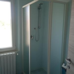 y baño con ducha y puerta de cristal. en Antico Casale Masini, en SantʼAndrea di Compito