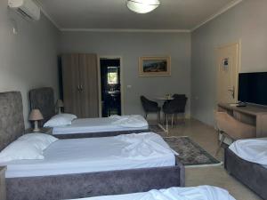 a hotel room with two beds and a television at Hotel Vila Arbri in Berat