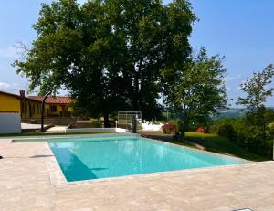 una piscina frente a una casa con un árbol en Colle Del Sole en Lastra a Signa