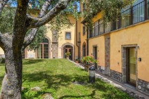 budynek z drzewem i trawnikiem w obiekcie 12 Amiata Mountain Charm Pool, Fast Wi-Fi, Free Parking w mieście Castel del Piano