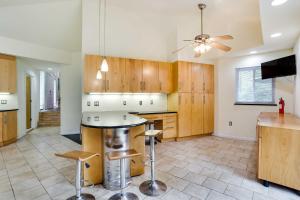 a kitchen with wooden cabinets and a ceiling fan at Spacious King of Prussia Home with 2 Game Rooms in King of Prussia