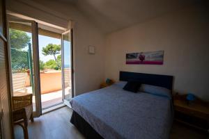 1 dormitorio con cama y ventana grande en La Terrazza Cipressa, en Cipressa