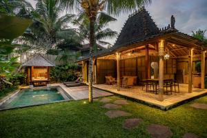 a villa with a swimming pool and a house at Arya Villas Ubud in Ubud