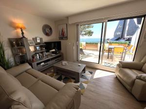 a living room with a couch and a view of the ocean at Bénodet: appartement avec terrasse, proche plage, thalasso et restaurants - FR-1-481-147 in Bénodet