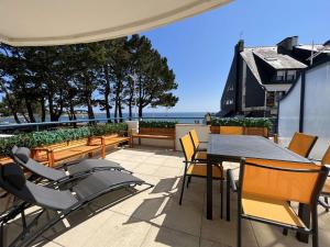 a patio with a table and chairs and the ocean at Bénodet: appartement avec terrasse, proche plage, thalasso et restaurants - FR-1-481-147 in Bénodet