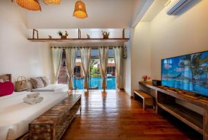 ein Wohnzimmer mit einem großen TV und einem Sofa in der Unterkunft Wendy the Pool Resort @ Koh Kood in Ko Kood
