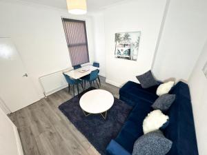 a living room with a blue couch and a table at Vicar Road in Liverpool