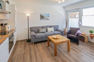 ein Wohnzimmer mit einem Sofa und einem Tisch in der Unterkunft Ferienwohnung Strandbox - Nähe Deich und Hundestrand in Norddeich