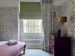 a bedroom with a bed and a window and a dresser at Cosy Weavers Cottage - Heart of Frome in Frome