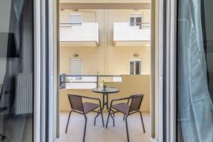 a balcony with a table and chairs in a room at Urban Apt Next University 14 in Heraklio