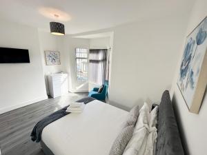 sypialnia z dużym łóżkiem i niebieskim krzesłem w obiekcie Vicar Road w Liverpoolu