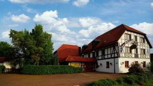 un grand bâtiment blanc avec un toit rouge dans l'établissement Hotel-Restaurant Zum Landgraf, à Wartmannsroth