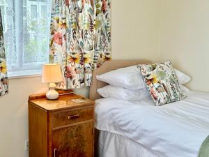 een slaapkamer met een bed en een tafel met een lamp bij The Cottage in York