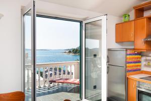 a kitchen with a balcony with a view of the ocean at Rimagis Apartments in Zaboric