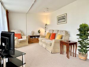 een woonkamer met 2 banken en een tv bij The Cottage in York