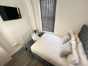 a bedroom with a bed and a tv on the wall at Vicar Road in Liverpool