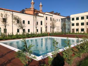 a large building with a swimming pool in front of it at Pellestrina Domus - Italianflat in Venice