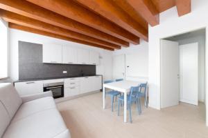 a kitchen and dining room with a white table and chairs at Pellestrina Domus - Italianflat in Venice