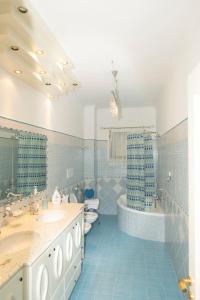 Baño azul con 2 lavabos y bañera en DOMUS LUNA, en Sorrento 18 fotos más