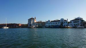 a group of houses on the water next to a harbor at Pellestrina Domus - Italianflat in Venice