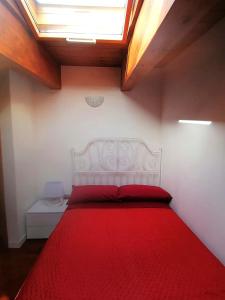 a bedroom with a red bed with a skylight at Emi Home in Montesilvano