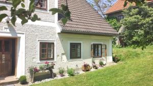 une maison blanche avec des plantes en pot devant elle dans l'établissement Naturparadies am Sonntagberg, 