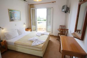 a bedroom with a bed and a table and a window at Anastasia Hotel Stalis in Stalís