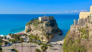 a castle on top of a rock in the ocean at The Queen Tropea in Tropea
