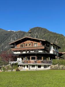 ein großes Gebäude vor einem Berg in der Unterkunft Hotel Gasthof Stoanerhof in Mayrhofen