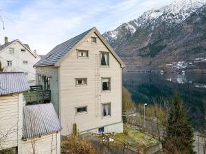 a house on a hill next to a body of water at Odda City Apartments in Odda