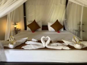 a bed with towels in the shape of swans on it at The View Hotel Sigiriya in Sigiriya