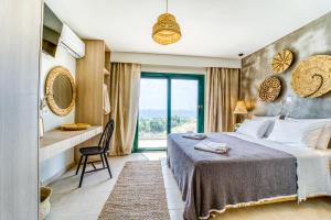 a bedroom with a large bed and a large window at Heliophos Villa Aelia in Kiotari