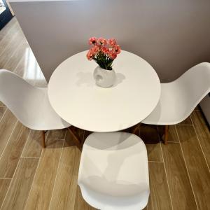 a white table with white chairs and a vase with flowers at Jo's downtown modern apartment. in Ioannina
