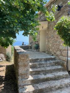 un conjunto de escalones de piedra que conducen a un edificio en charmante bergerie à Cargese tres belle vue mer avec jardin en Cargèse