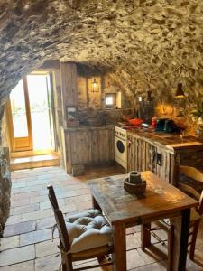eine Küche mit einem Tisch und einem Herd Top-Backofen in der Unterkunft charmante bergerie à Cargese tres belle vue mer avec jardin in Cargèse