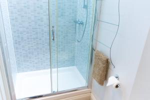 y baño con ducha y puerta de cristal. en York Terrace Apartments - Norwich City en Norwich