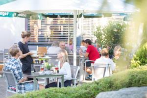 a group of people sitting at tables in an outdoor restaurant at Hotel Restaurant JÄGERHAUS in Meckenbeuren