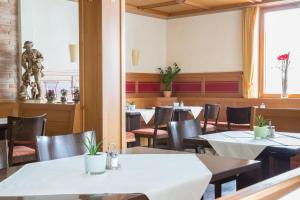 uma sala de jantar com mesas e cadeiras e uma estátua em Hotel Jägerhaus em Meckenbeuren