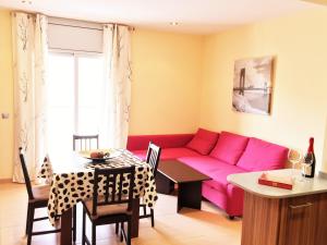 リョレート・デ・マルにあるLloret Beach Apartments - SeaViewのリビングルーム(ピンクのソファ、テーブル付)