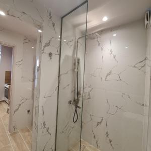 a shower with a glass door in a bathroom at Jo's downtown modern apartment. in Ioannina