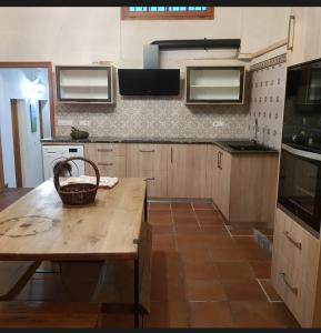 a kitchen with a wooden table with a basket on it at Masia cerca del río muga in Terrades