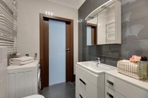 a bathroom with a sink and a toilet and a mirror at Old Town by Welcome Apartment in Gdańsk +188 photos