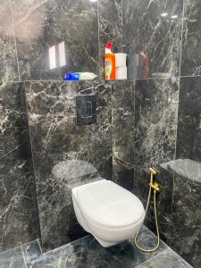 a bathroom with a toilet and a black marble wall at Levi’s room’s in Eilat