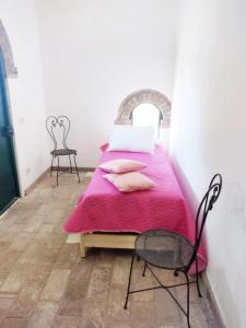 1 dormitorio con 1 cama con manta rosa en Relais Casale Il Poggetto - OLEANDRI en Cecina