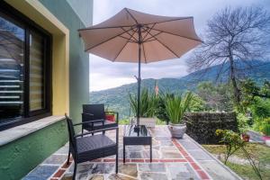 a patio with two chairs and an umbrella at Maria's House in Zagora