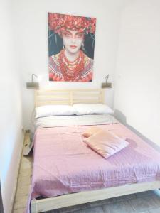 1 dormitorio con 1 cama con una pintura en la pared en Relais Casale Il Poggetto - OLEANDRI en Cecina