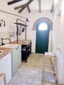 a kitchen with a green door and a sink at Relais Casale Il Poggetto - OLEANDRI in Cecina