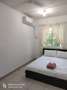 a bedroom with a bed with two brown towels on it at TulipVilla Homestay in Kampong Parit