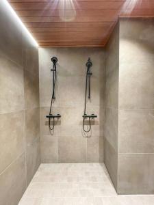 a shower with three shower heads on a wall at Black Work Levi Aarni in Kittilä
